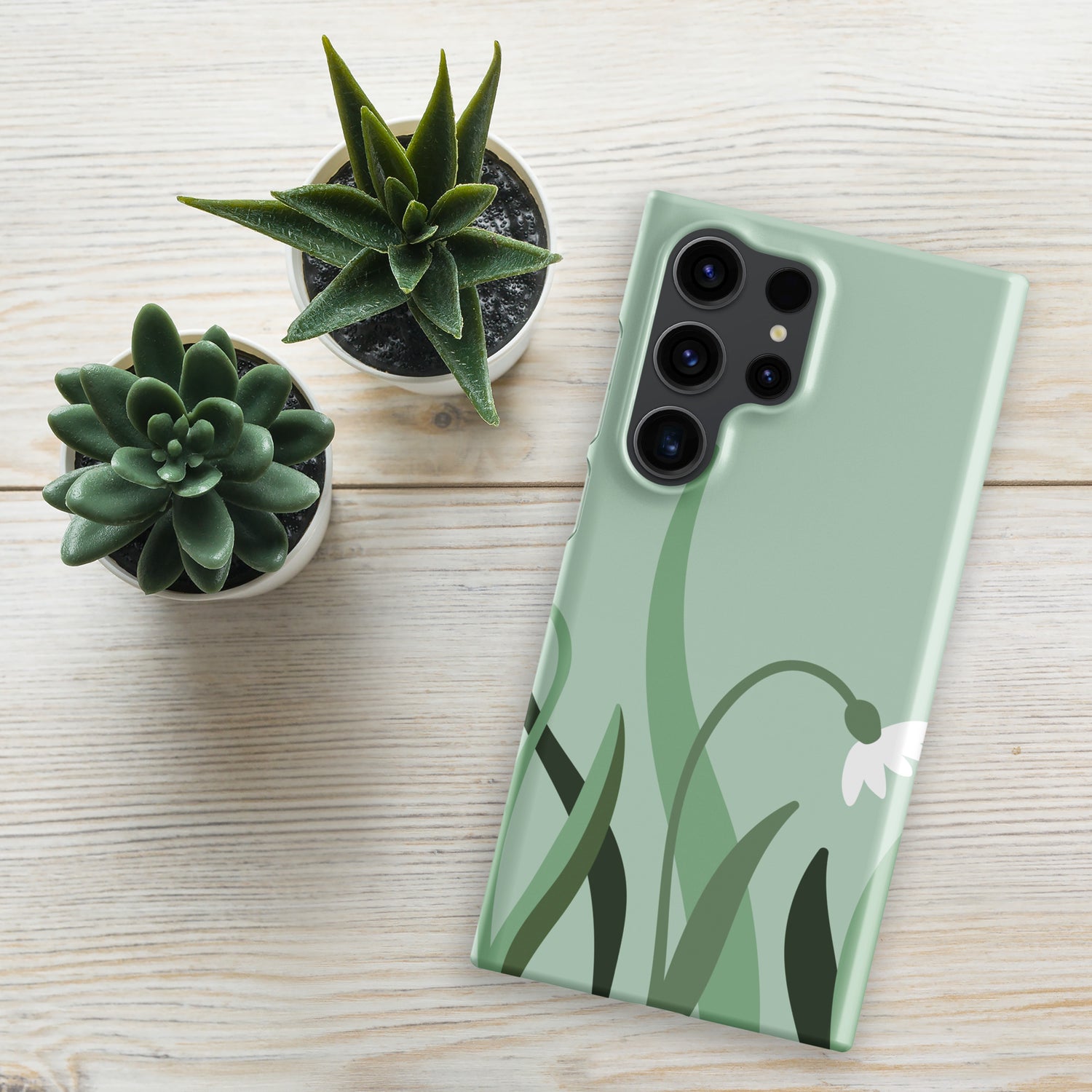 A light green Samsung Snap case laying on the table with a minimal flower design on it. 